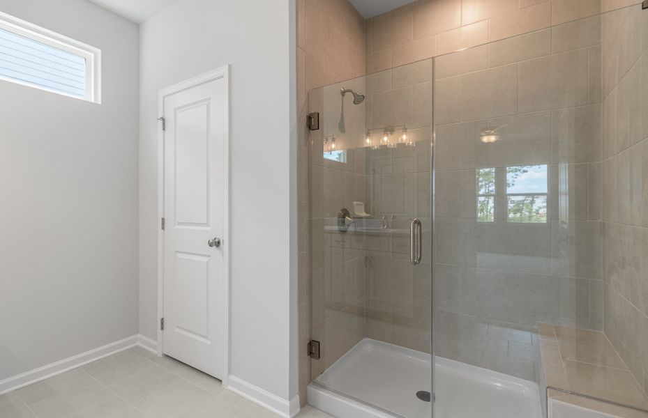 Relax in the Owner's Bath including a farmless walk-in shower equipped with a seating bench
