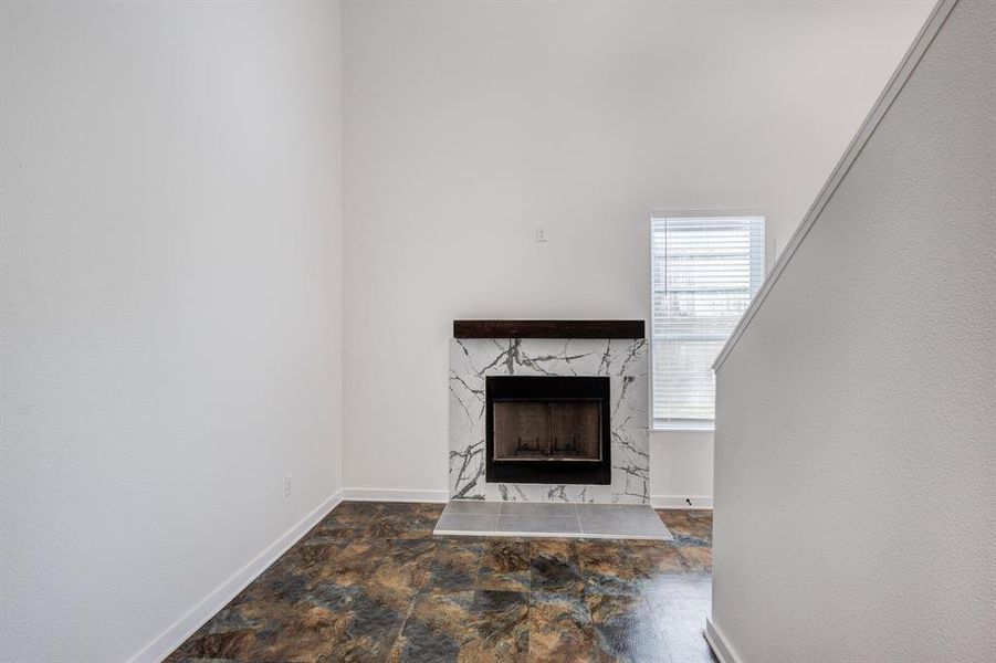 Unfurnished living room featuring tile patterned flooring and a high end fireplace