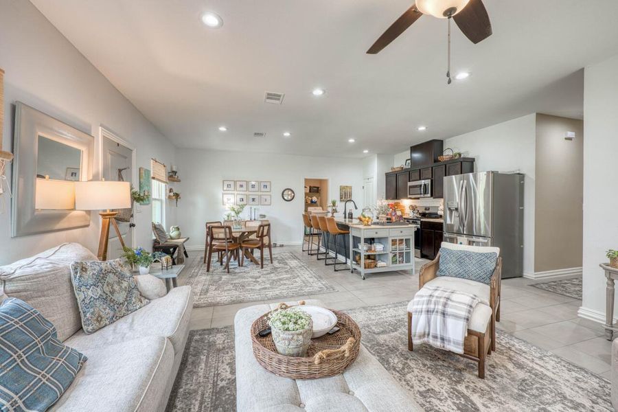 Open-concept living space featuring light-toned flooring, recessed lighting, and a ceiling fan