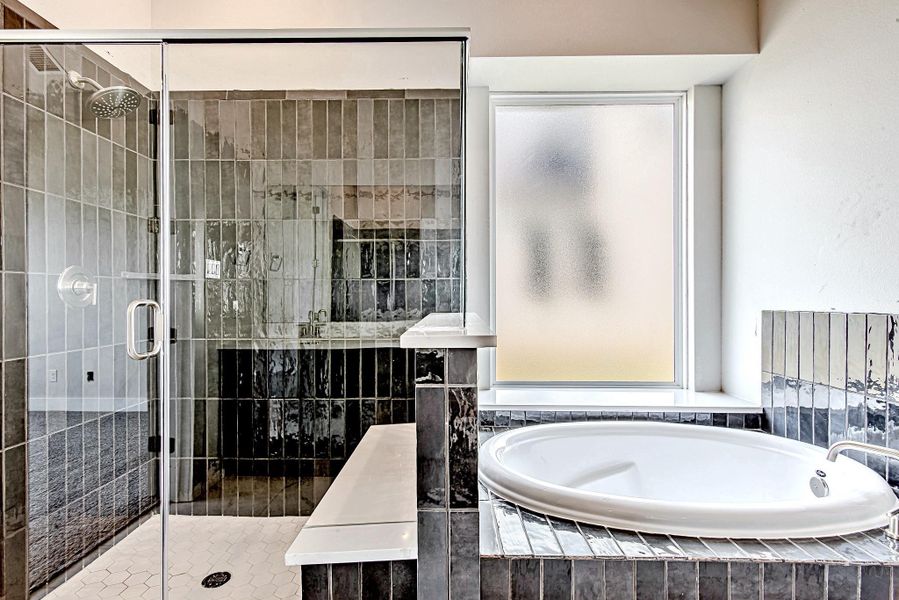 Spa-like en suite features a soaking tub and glass-enclosed shower. Spa-like en suite features a soaking tub and glass-enclosed shower.