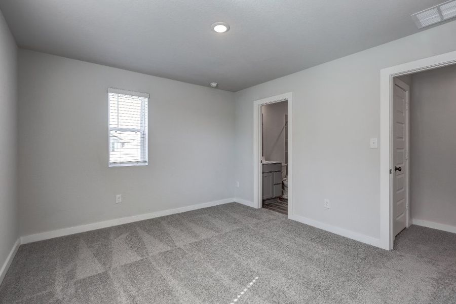 A room with a carpet and a door.