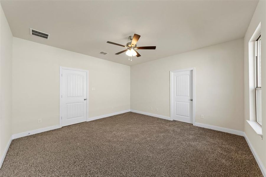 Carpeted empty room with ceiling fan