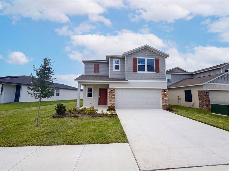 Front exterior of a new home in Wynnstone, Davenport, FL, highlighting curb appeal (Image 16). Front exterior of a new home in Wynnstone, Davenport, FL, highlighting curb appeal (Image 16).