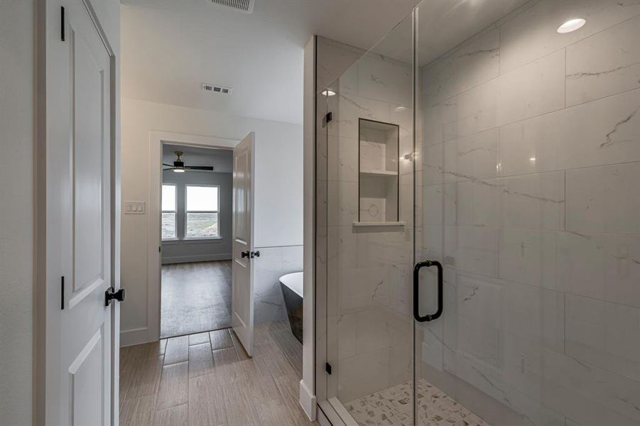 Bathroom with a freestanding tub, visible vents, a shower stall, and wood finished floors