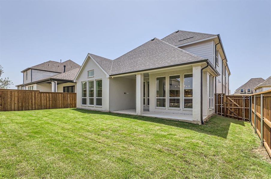 Rear view of property with a patio area and a lawn