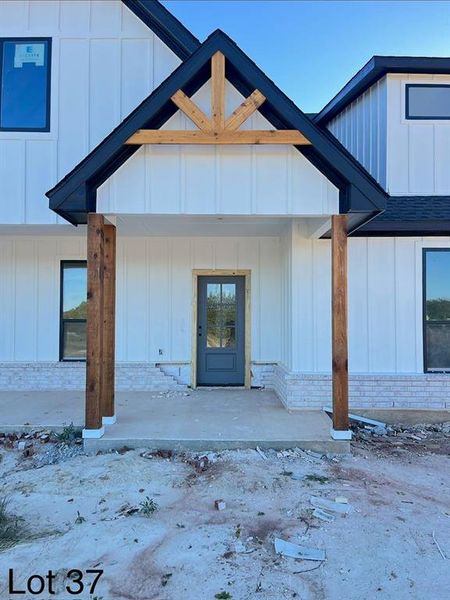 Property entrance featuring board and batten siding and a porch