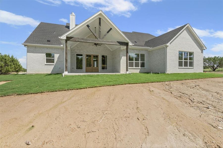 Back of property featuring ceiling fan, a patio area, brick siding, and a yard Back of property featuring ceiling fan, a patio area, brick siding, and a yard