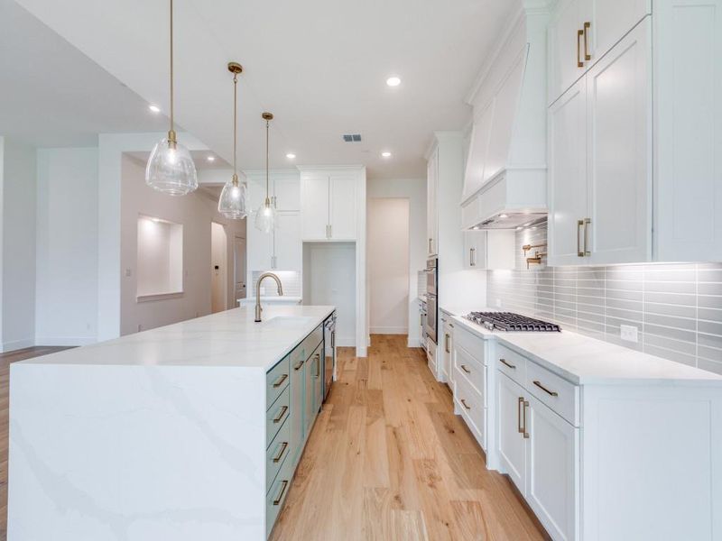 Featuring upgraded design elements like a waterfall island, pot filler, gorgeous flooring and double stacked cabinetry, this dream kitchen is waiting for you to make it your own!