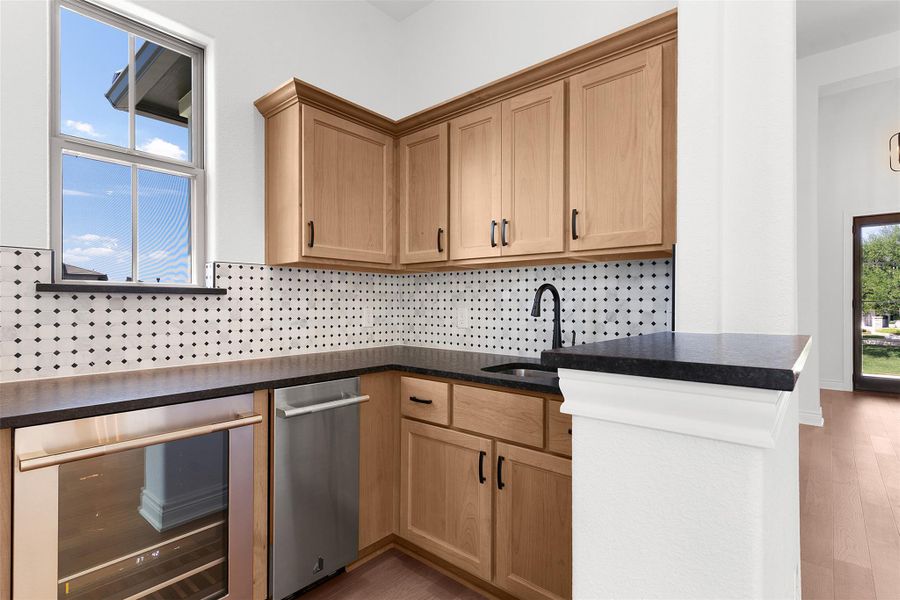 Compact and efficient, this wet bar includes a sink, refrigerator, and built-in dishwasher.