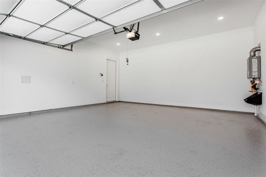 Garage featuring water heater and a garage door opener