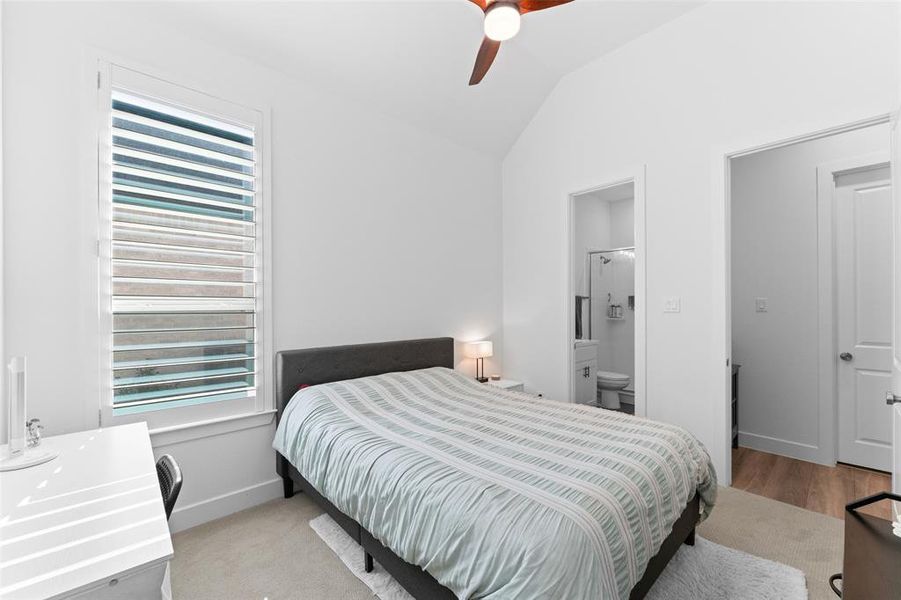 Bedroom featuring a vaulted ceiling with a ceiling fan, a window with horizontal blinds, and carpeted flooring