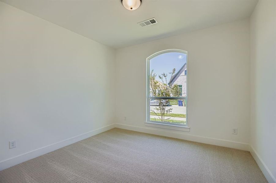 Empty room featuring light colored carpet and baseboards