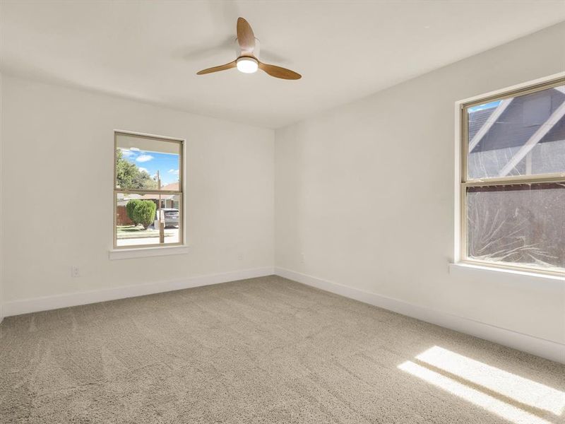 Empty room featuring carpet flooring and ceiling fan