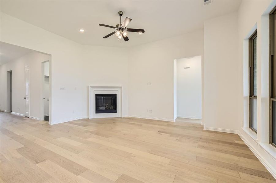 Unfurnished living room with ceiling fan and light hardwood / wood-style flooring