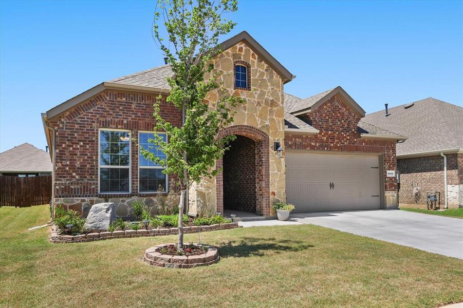 View of front of house with stone siding, brick siding, concrete driveway, and a garage View of front of house with stone siding, brick siding, concrete driveway, and a garage