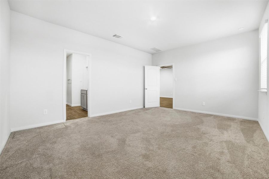 Unfurnished bedroom featuring carpet floors and ensuite bathroom Unfurnished bedroom featuring carpet floors and ensuite bathroom