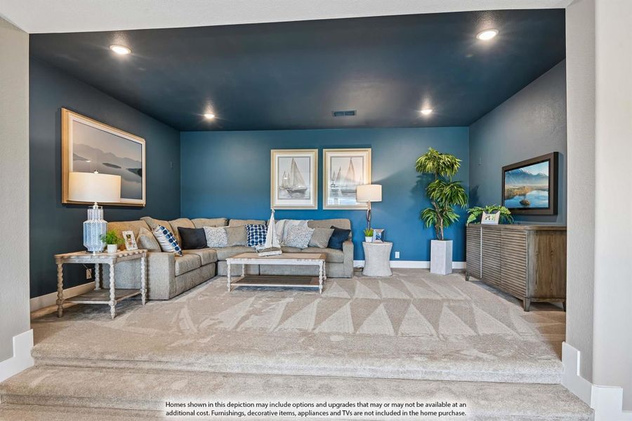 Living room with blue accent walls, sectional sofa, patterned carpet, and wall art Living room with blue accent walls, sectional sofa, patterned carpet, and wall art