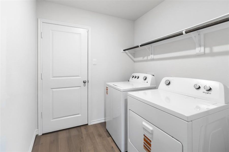 Laundry area with dark wood-style flooring and washer and clothes dryer