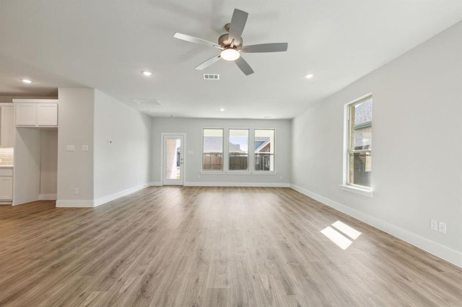 Unfurnished living room featuring ceiling fan, light wood-type flooring, and sink