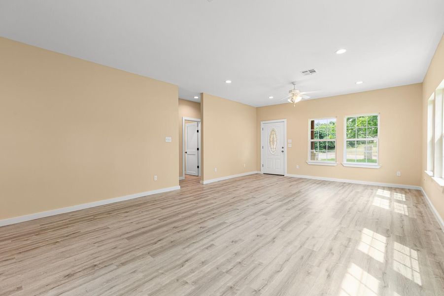 Unfurnished living room featuring ceiling fan, light wood-type flooring, and recessed lighting