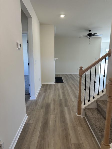 Corridor featuring light wood-style flooring, stairway, and recessed lighting