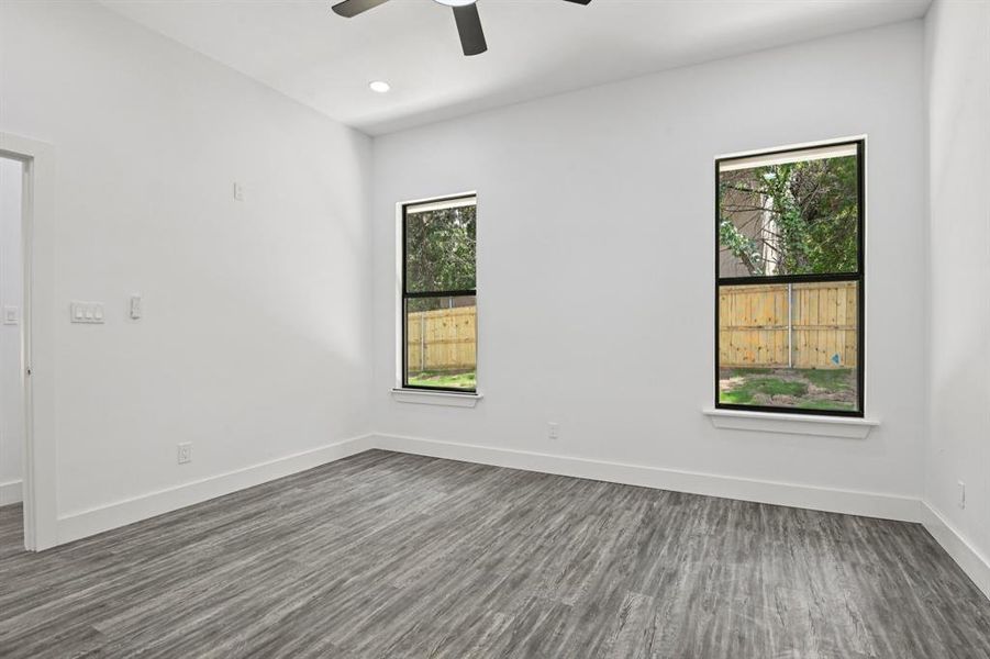 Empty room with a ceiling fan, dark wood-style floors, and recessed lighting Empty room with a ceiling fan, dark wood-style floors, and recessed lighting
