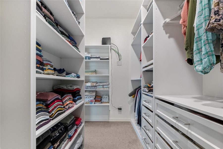 Ample built-in storage solutions and hanging space define this functional walk-in closet. Ample built-in storage solutions and hanging space define this functional walk-in closet.
