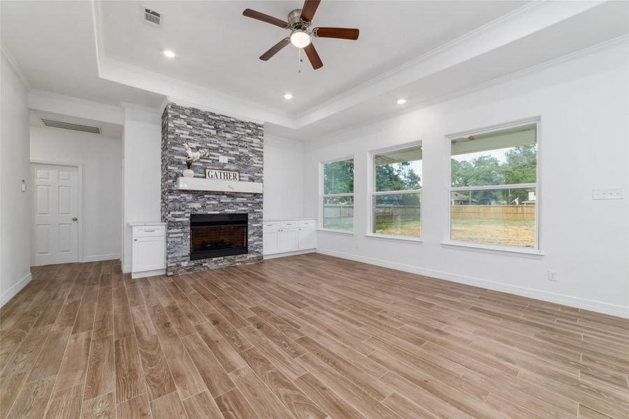 Living room features tray ceiling with a gorgeous gas fireplace with built-ins, and oversized windows, so you can enjoy lots of natural light. Living room features tray ceiling with a gorgeous gas fireplace with built-ins, and oversized windows, so you can enjoy lots of natural light.