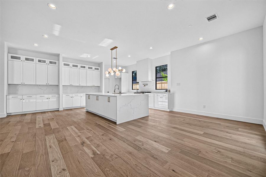 Lots of cabinets all along side wall with cabinet lighting on top shelf. Lots of cabinets all along side wall with cabinet lighting on top shelf.