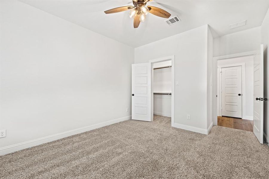 Unfurnished bedroom with carpet flooring, ceiling fan, and a closet