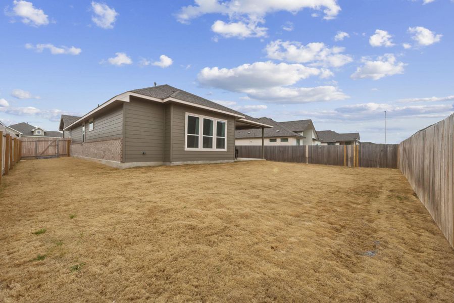 Rear view of property featuring a fenced backyard, a gate, and a patio