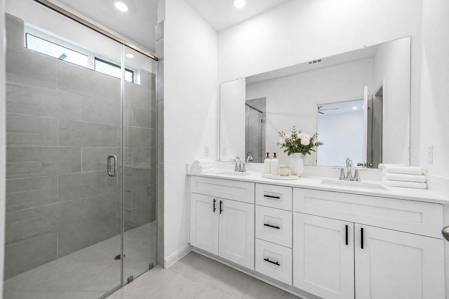 The en-suite bath featuring dual vanity sinks and a modern walk in shower. Virtually Staged The en-suite bath featuring dual vanity sinks and a modern walk in shower. Virtually Staged