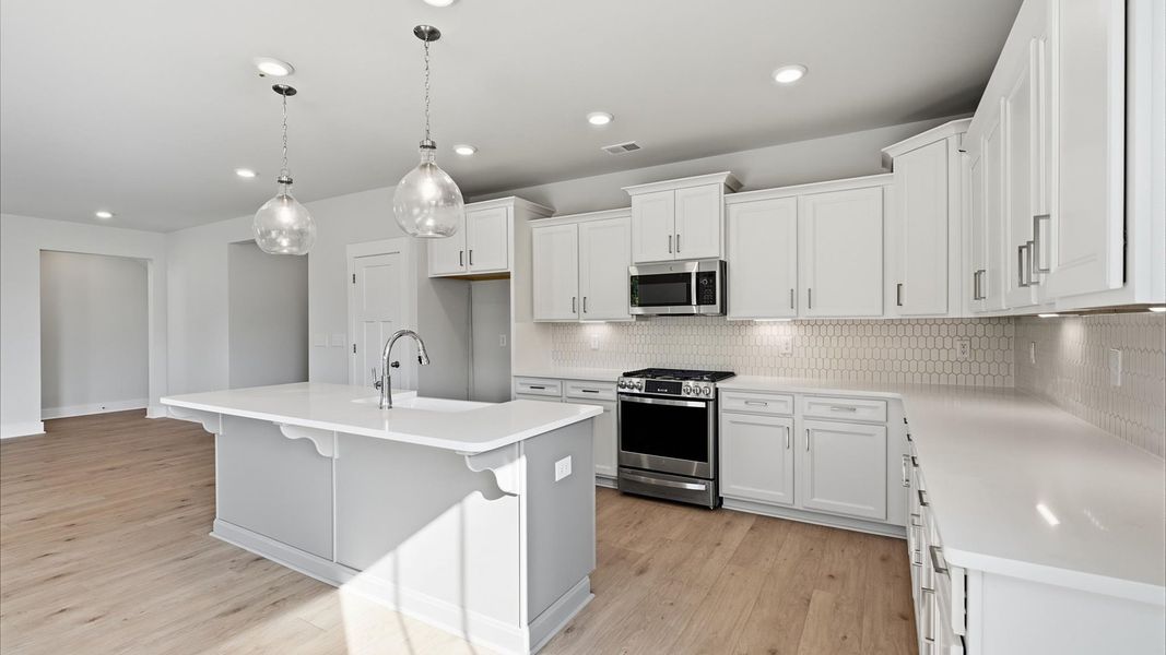 Highly skilled craftsmanship shines in this modern kitchen with pendant lighting and a central island focal point