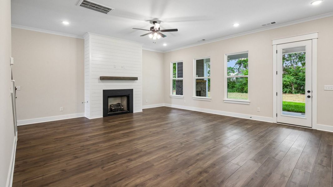 Gathering room with ceiling fan, fireplace, and hard surface flooring Gathering room with ceiling fan, fireplace, and hard surface flooring
