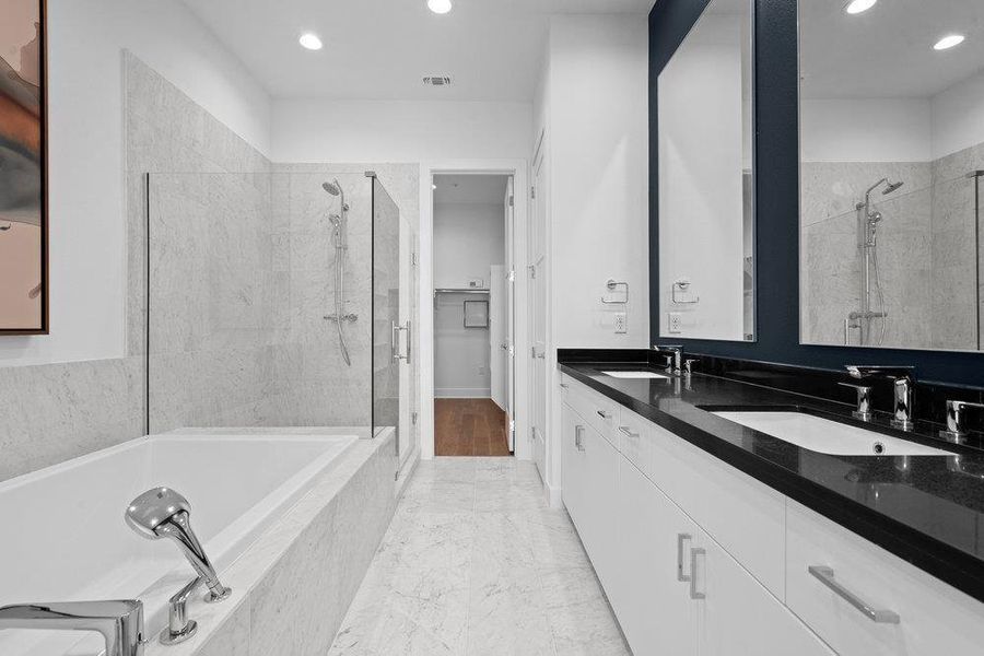 Full bathroom featuring double vanity, a marble finish shower, a garden tub, recessed lighting, and a walk in closet