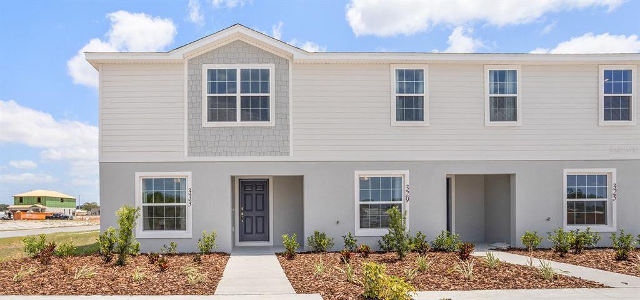 Front exterior of a new home in Harbor at Lake Henry - Townhomes, Winter Haven, FL, highlighting curb appeal (Image 1). Front exterior of a new home in Harbor at Lake Henry - Townhomes, Winter Haven, FL, highlighting curb appeal (Image 1).