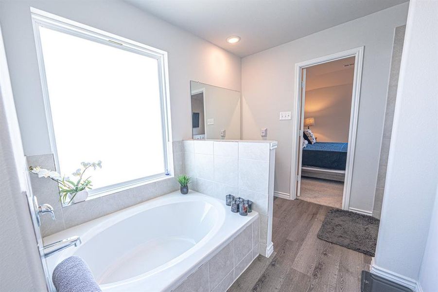 Full bath with a bath, dark wood-type flooring, and ensuite bathroom