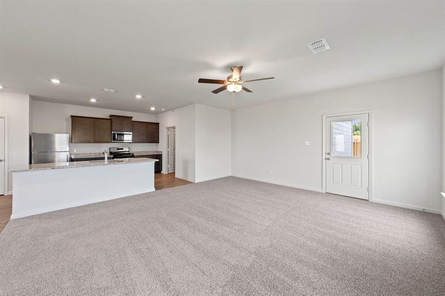 Living room featuring ceiling fan and light colored carpet