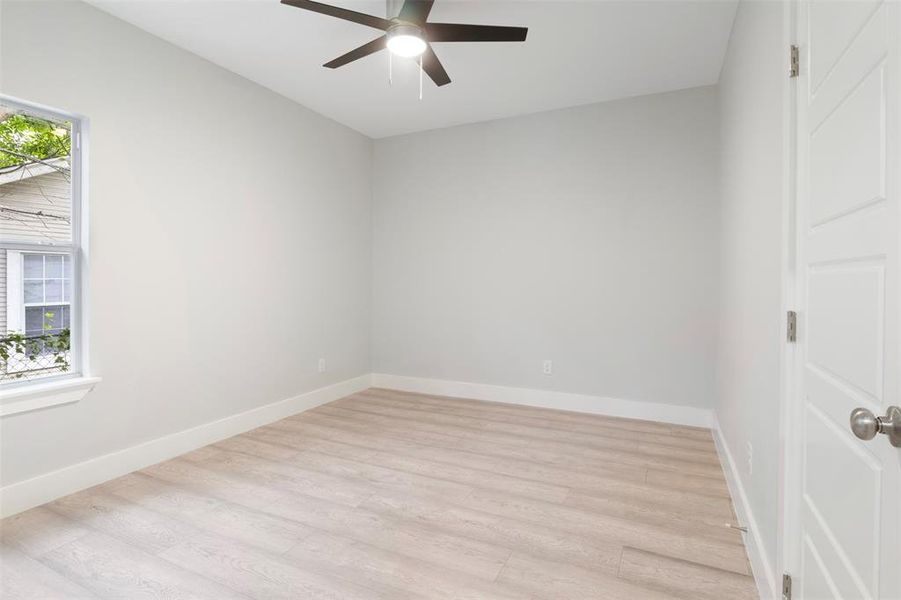 Empty room with light wood-type flooring and ceiling fan