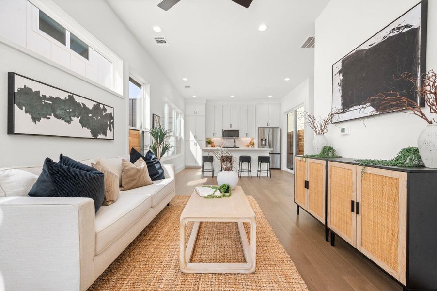 Living room featuring light wood-style flooring, a ceiling fan, and recessed lighting