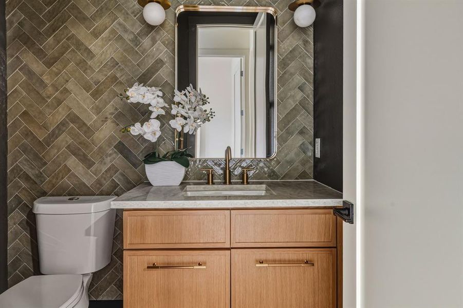Half bathroom with vanity, tile walls, and tasteful backsplash