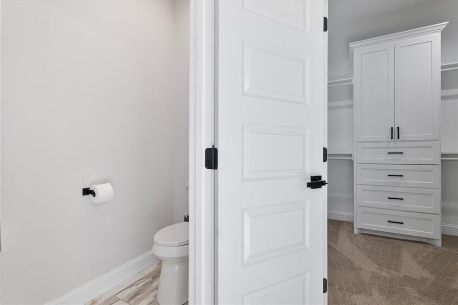 Bathroom featuring toilet and baseboards