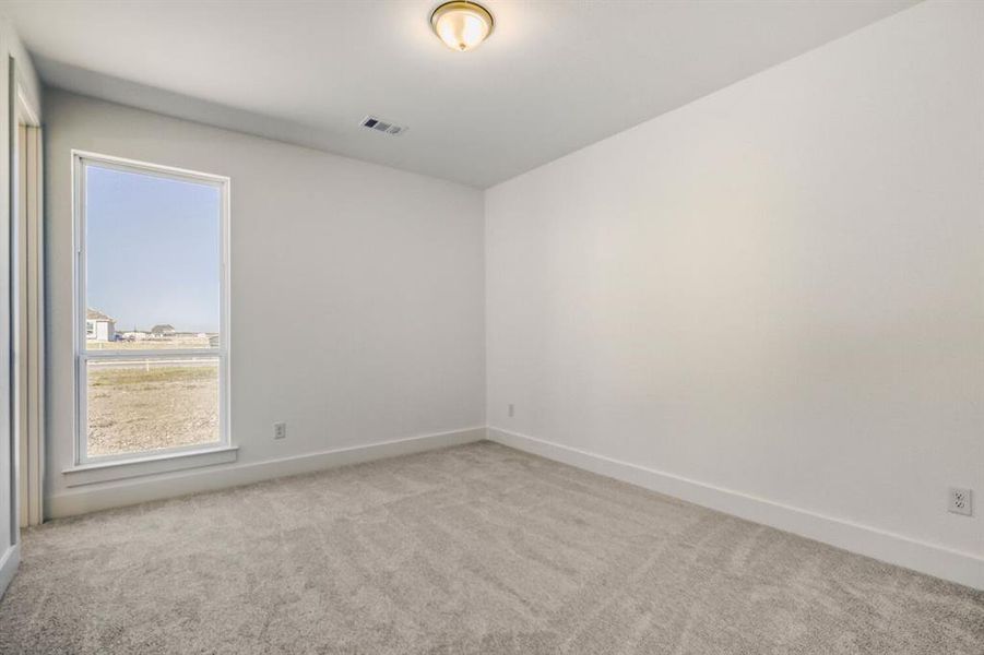 Spare room with baseboards and light colored carpet