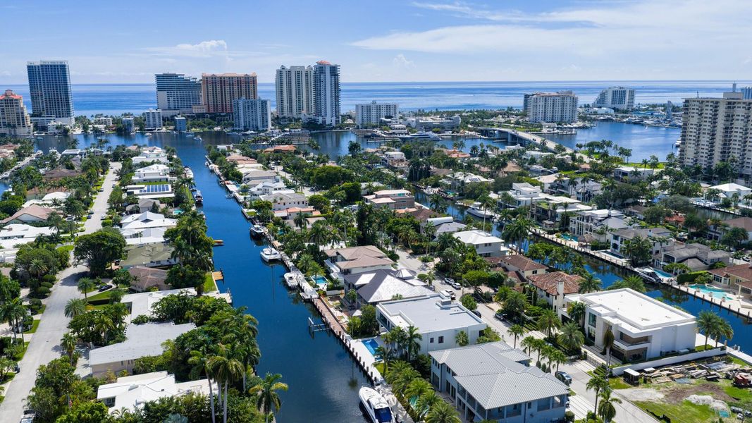 A vibrant neighborhood scene showing waterfront homes leading toward the Fort Lauderdale coastline and ocean horizon. A vibrant neighborhood scene showing waterfront homes leading toward the Fort Lauderdale coastline and ocean horizon.