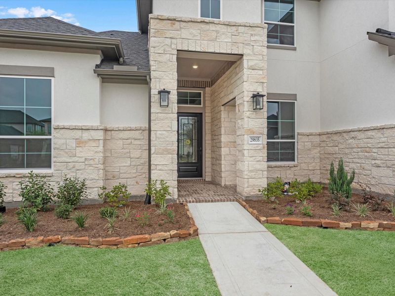 Front exterior of a new home in Cross Creek Ranch 65′, Fulshear, TX, highlighting curb appeal (Image 18). Front exterior of a new home in Cross Creek Ranch 65′, Fulshear, TX, highlighting curb appeal (Image 18).