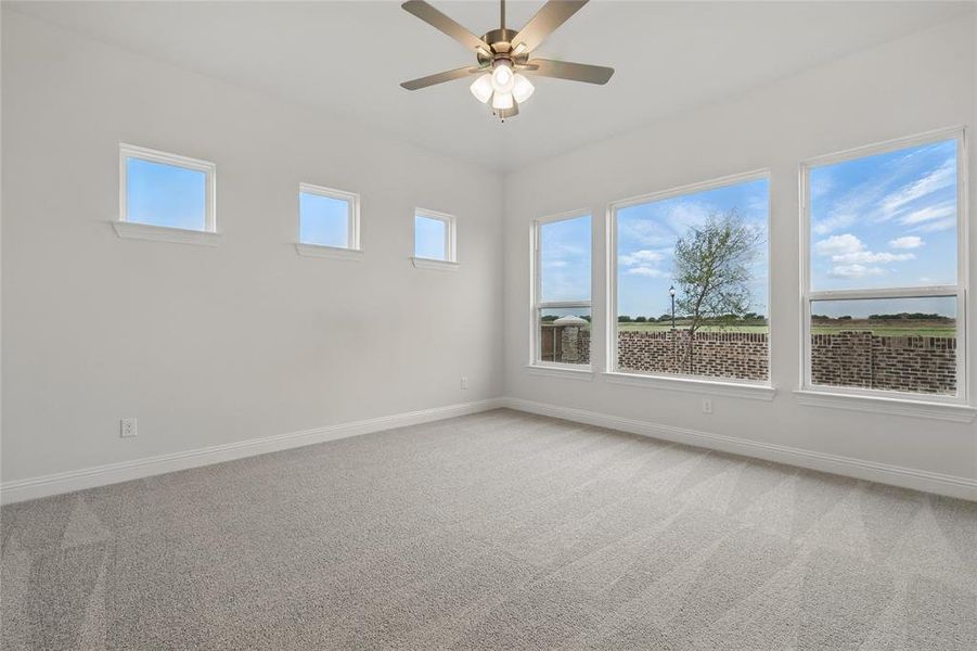 Unfurnished room with ceiling fan, light carpet, and baseboards