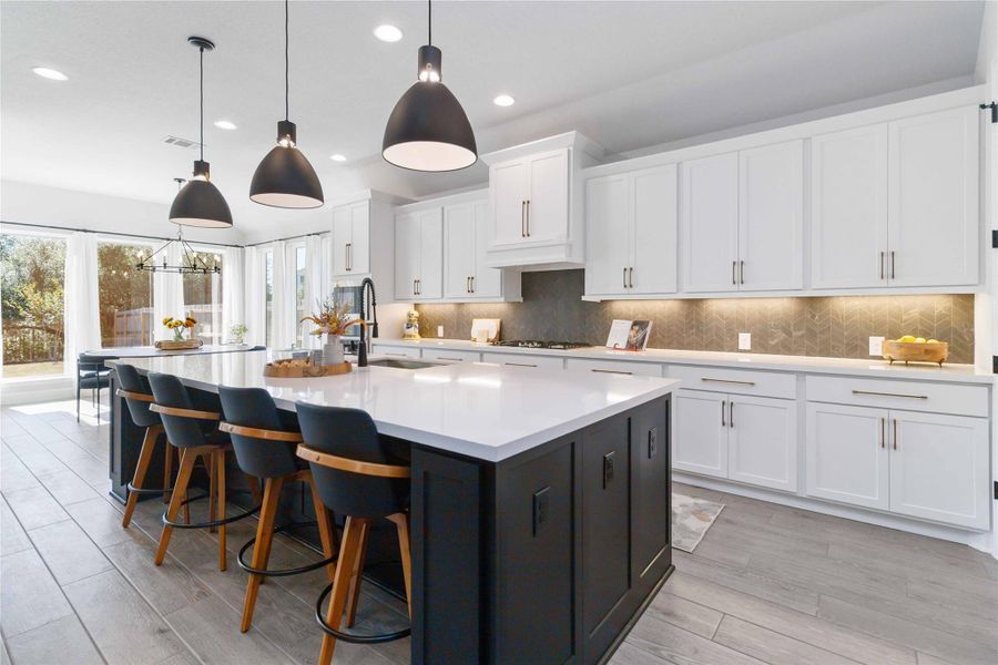 Kitchen with white cabinets, pendant lighting, backsplash, and recessed lighting Kitchen with white cabinets, pendant lighting, backsplash, and recessed lighting