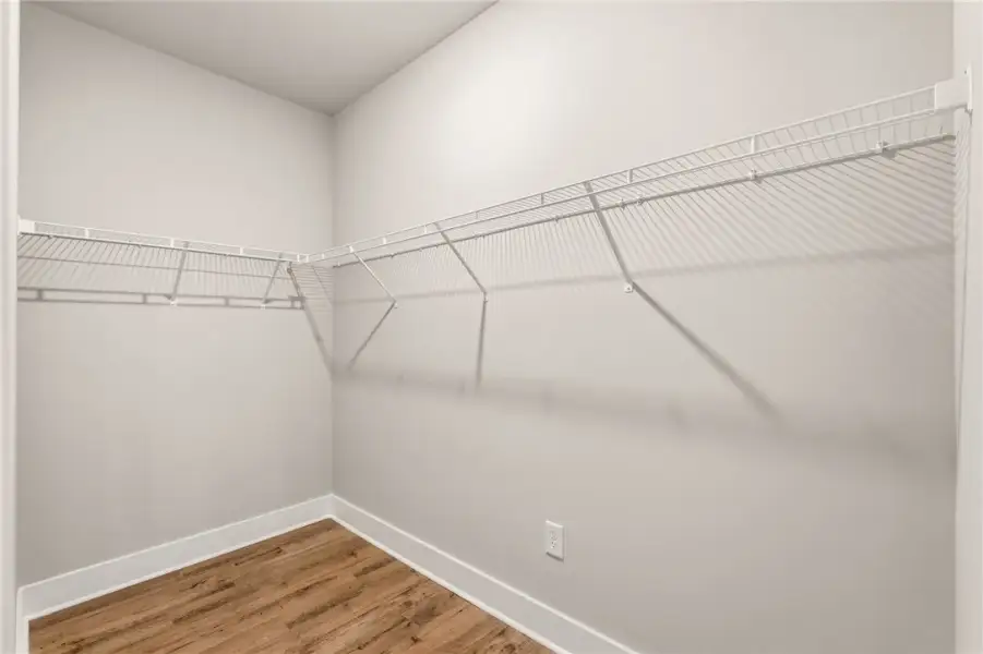 A spacious walk-in closet features durable wire sh A spacious walk-in closet features durable wire sh