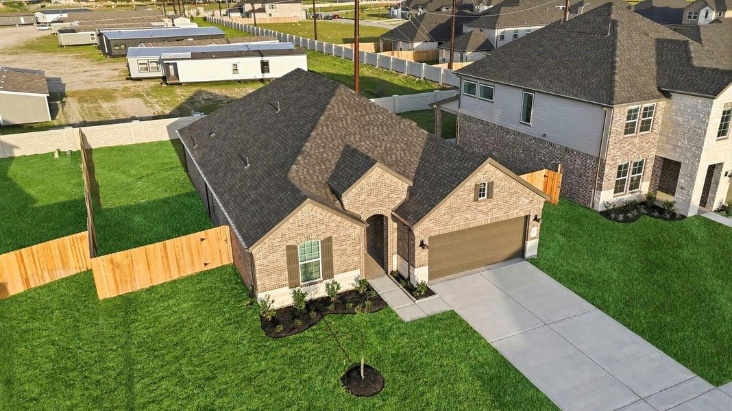 An aerial view of the newly built one story home with traditional architecture, a two car garage and a landscaped front yard An aerial view of the newly built one story home with traditional architecture, a two car garage and a landscaped front yard