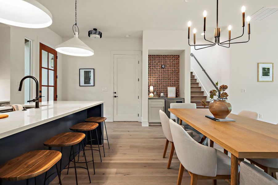 Dining area featuring stairs, light wood-style floors, and a chandelier